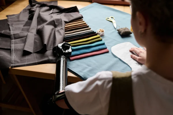 myoelectric-arm-of-young-female-tailor-choosing-fa-2025-02-11-15-48-46-utc